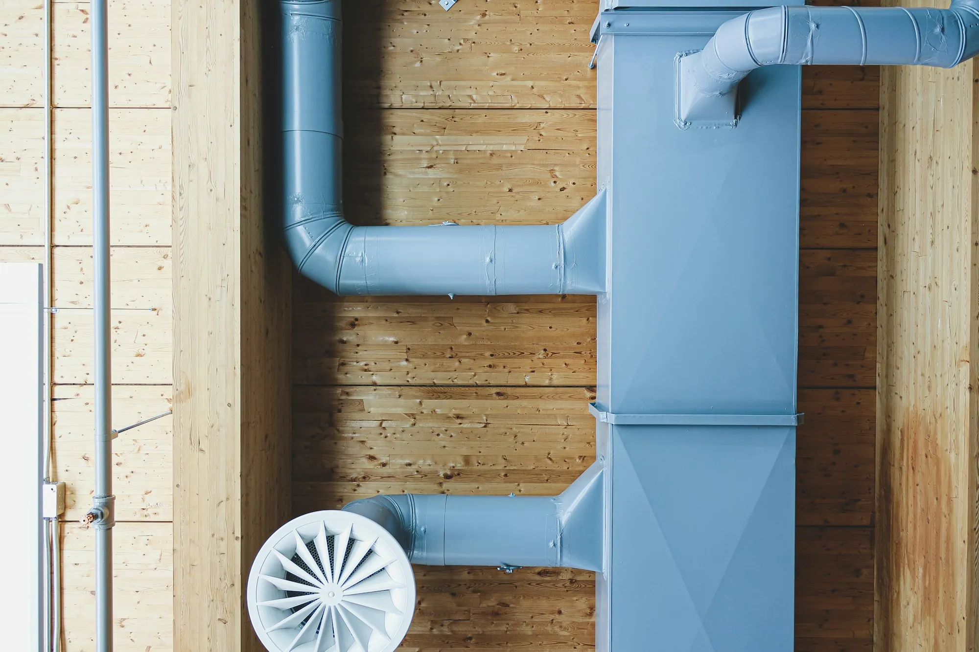 Light blue ductwork with a round ceiling diffuser