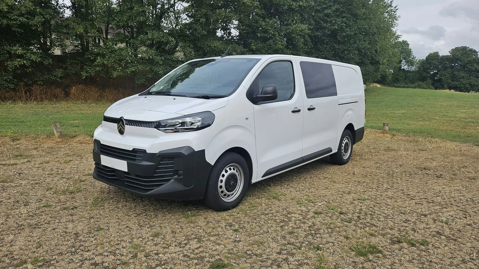 White service van parked on a gravel lot